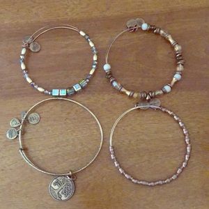 Four beautiful gold tone Alex and Ani bracelets.